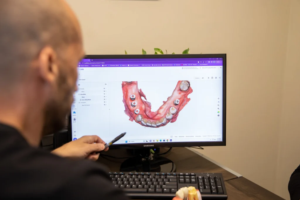 Dr. Halaby observing dental implants on a computer at The Dental Implant Center in Farmington, NY