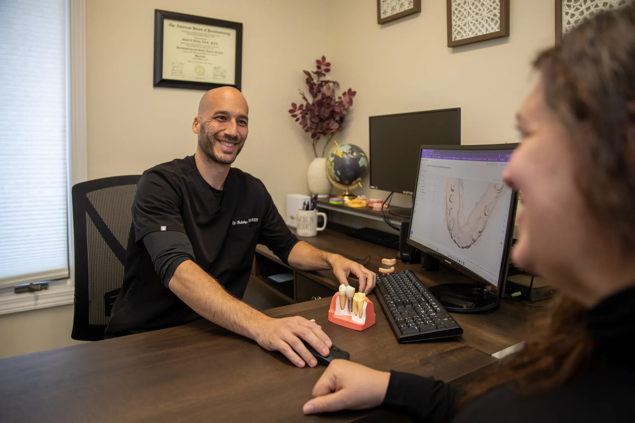 Dr. Halaby in a personal consultation with a patient at The Dental Implant center in Farmington, NY
