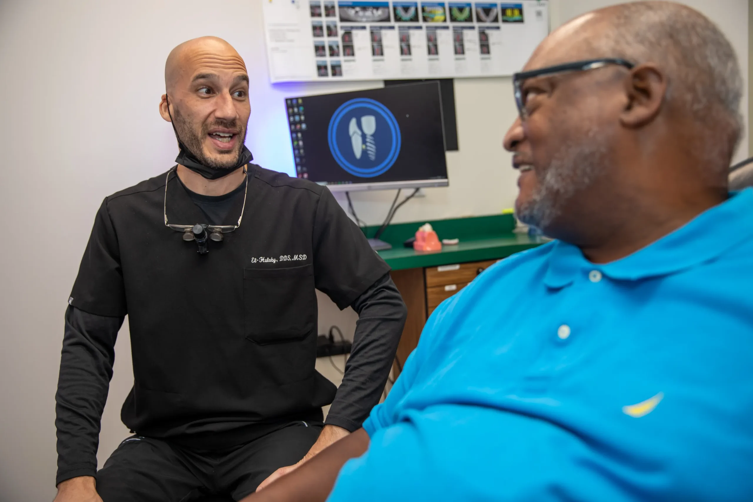 Dr. Halaby speaking amicably with a patient in his office at The Dental Implant Center in Farmington, NY